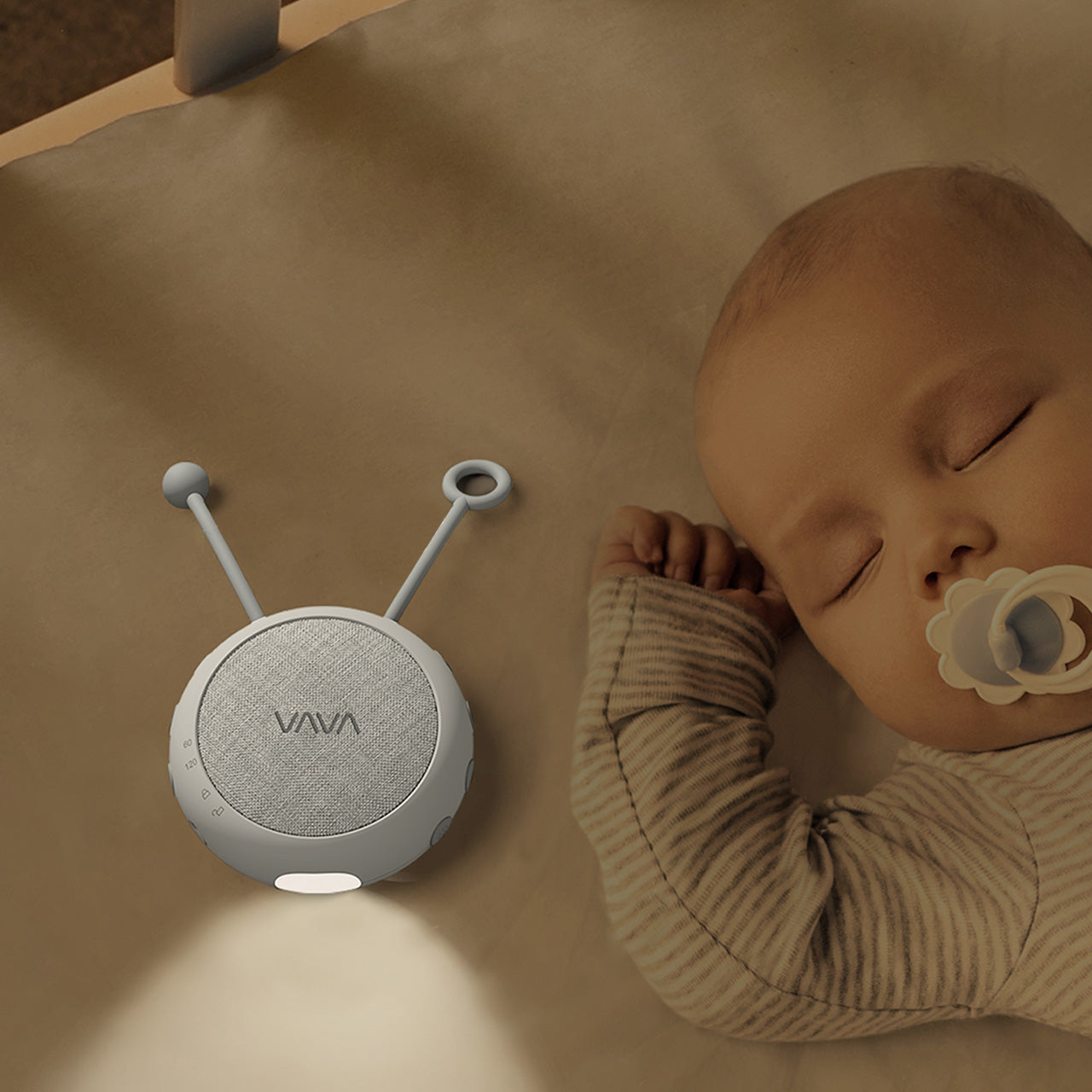 VAVA Twinkle Soother nightlight on a crib mattress next to a sleeping baby.