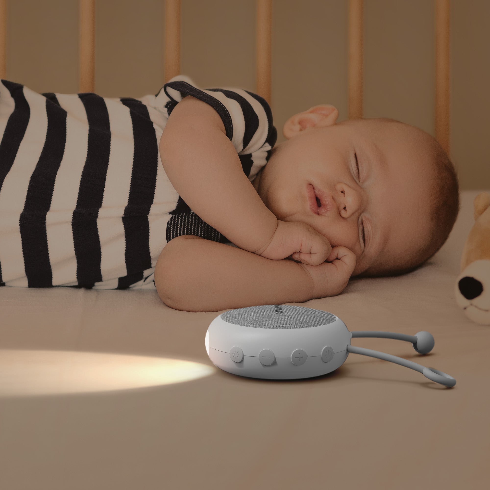 VAVA Twinkle Soother sound machine with baby sleeping on the bed