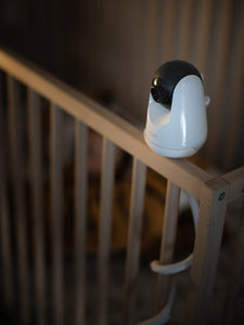 VAVA baby monitor camera installed on a wooden crib railing