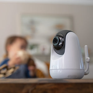 VAVA baby monitor camera on a table with a child in the background