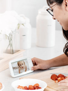 Caregiver checking in on baby on a VAVA baby monitor