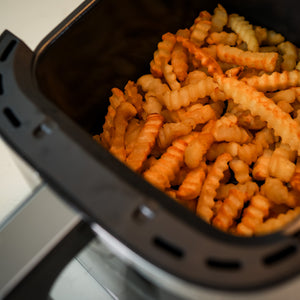 VAVA air fryer cooking basket with fries in it.