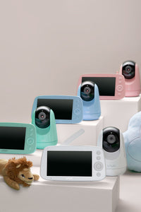 VAVA pink, blue, green, and white baby monitors and cameras with a stuffed cloud and stuffed lion toy