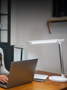 Woman working on her laptop with a white VAVA desk lamp next to her