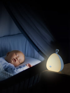 The VAVA Peep-a-Light on a nightstand with a sleeping baby in the background