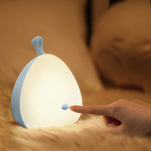 A person pointing to the VAVA Peep-a-Light resting on a rug.