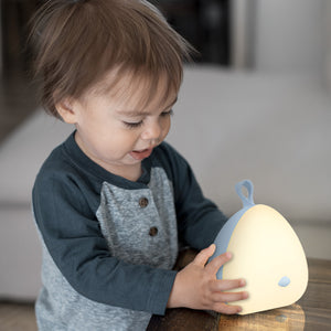 Child holding the VAVA Peep-a-Light resting on a table.