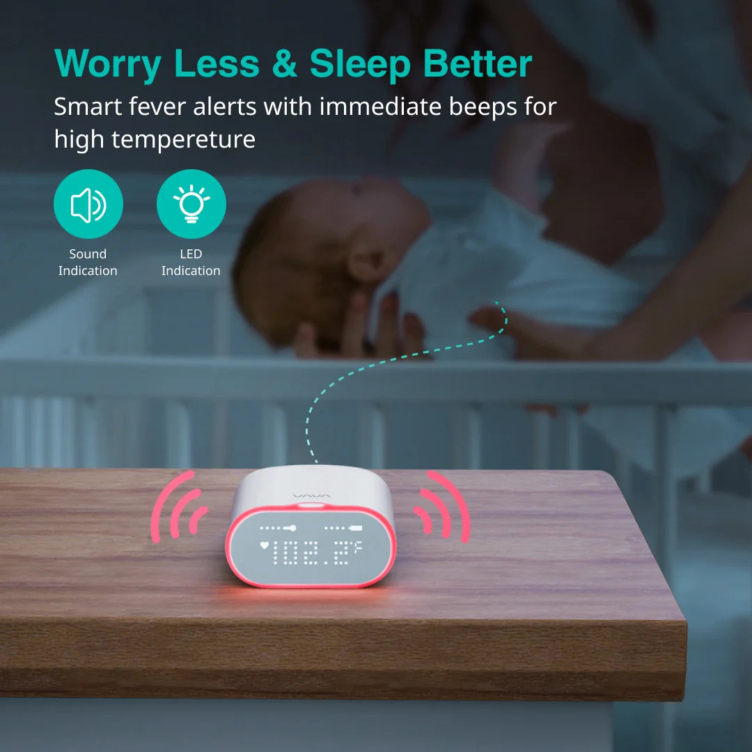 Smart fever alert device on a table with a baby in a crib in the background