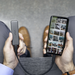 Hands holding a VAVA portable SSD hooked up to a smartphone